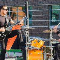 Jesse Ray and the Carolina Catfish band member putting his foot on the drums and playing guitar.